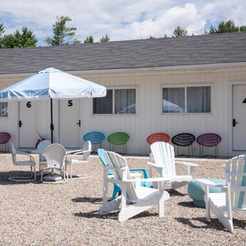 a group of chairs and an umbrella in front of a building at Motel Chelsea in Chelsea