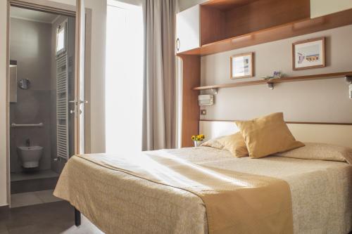 a bedroom with a bed and a bathroom at Hotel Sandra in Rimini