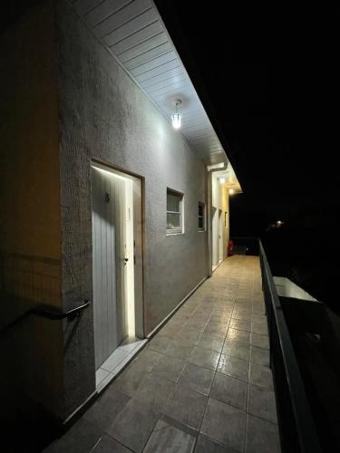 a dark hallway with a white door in a building at Kitnets da Lane in Campos do Jordão