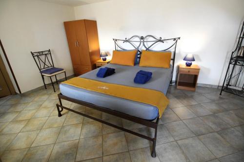 a bedroom with a bed with yellow and blue pillows at L' Arca Residence in Cefalù