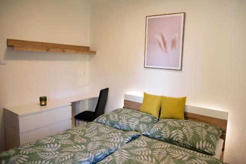 een slaapkamer met een bed met gele kussens en een bureau bij Apartment with a sun terrace,privat parking in Banská Bystrica