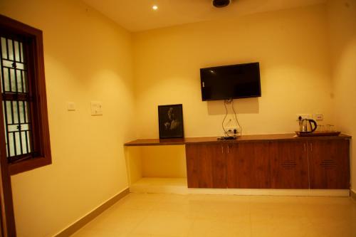 a living room with a flat screen tv on a yellow wall at WESTN Resorts in Kuttālam