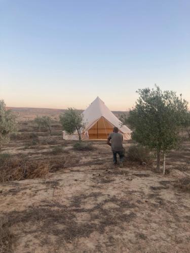 een man voor een tent in de woestijn bij Skyline eco-camp in Mitzpe Ramon