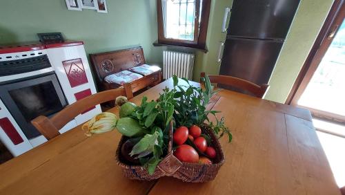 una mesa con una cesta de frutas y verduras. en Tranquillo ed accogliente appartamento CIR VDA-Valpelline 0003, en Valpelline