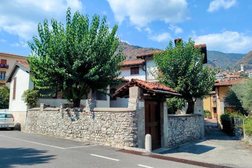 a house with a stone wall and two trees at Cadepulan in Como