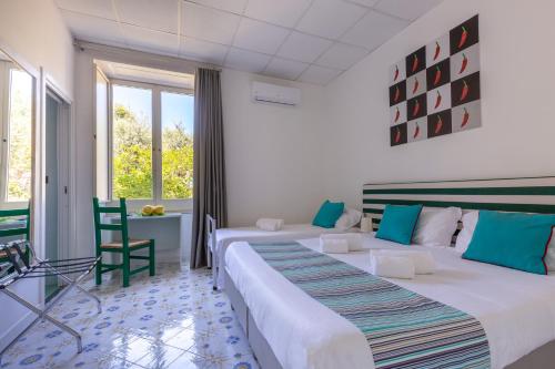 Habitación de hotel con 2 camas y ventana en Hotel Spicy, en Sorrento