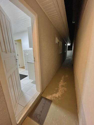 an empty hallway with a door and water on the floor at Kitnets da Lane in Campos do Jordão