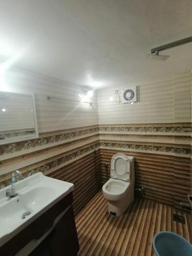 a bathroom with a white toilet and a sink at Queens Residency in Trichūr