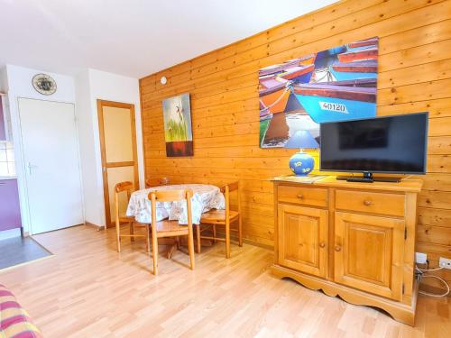 un salon avec une télévision sur un mur en bois dans l'établissement Studio Sud Confort avec Terrasse à Flaine - FR-1-425-192, à Arâches-la-Frasse