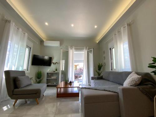 a living room with a couch and chairs and a tv at ILoveHome Grez in Kalamata