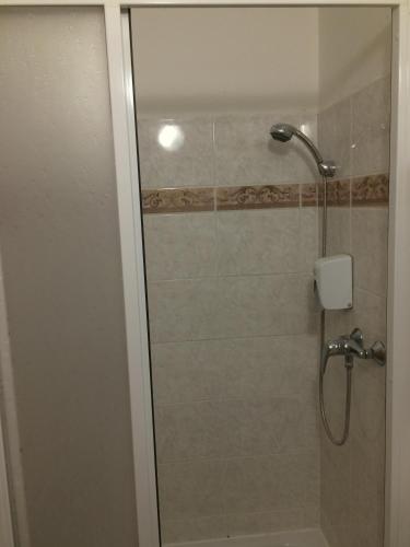a shower with a glass door in a bathroom at Penzion Xaver in Blučina