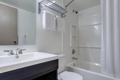 a bathroom with a sink and a toilet and a tub at Heritage Inn Hotel & Convention Centre - Saskatoon in Saskatoon