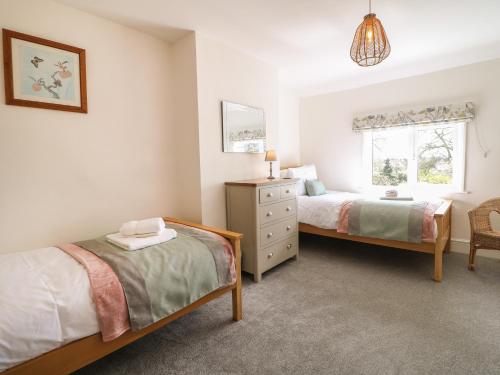1 dormitorio con 2 camas y ventana en Hops Cottage en Ashbourne