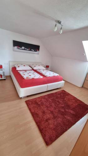 ローテンブルク・オプ・デア・タウバーにあるFerienwohnung Schützenstrasseのベッドルーム1室(ベッド1台、赤いラグ付)