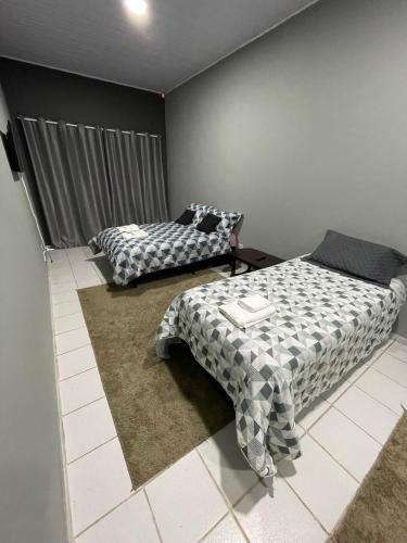 a bedroom with two beds in a room at Kitnets da Lane in Campos do Jordão