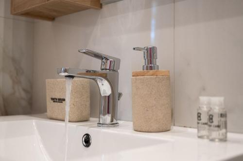 a bathroom sink with two faucets on a counter at Amalia in Matala