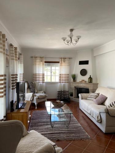 a living room with two couches and a tv at Casa do Canto - Uma casa no campo, perto da praia. in Óbidos