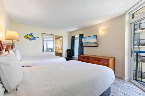 a hotel room with two beds and a window at Boardwalk Resort Beachfront Condo by Hosteeva in Myrtle Beach