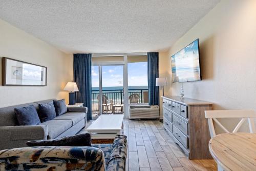 a living room with a couch and a view of the ocean at Boardwalk Resort Beachfront Condo by Hosteeva in Myrtle Beach