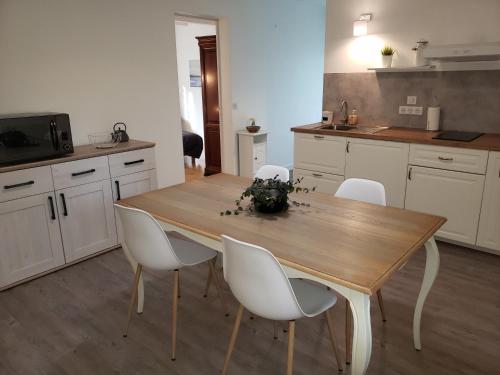 cocina con mesa de madera y sillas blancas en Appartement FONTARRABIE, en Saint-Jacques