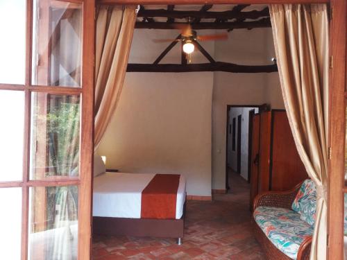 a bedroom with a bed and a window at Casona CHARA in Barichara