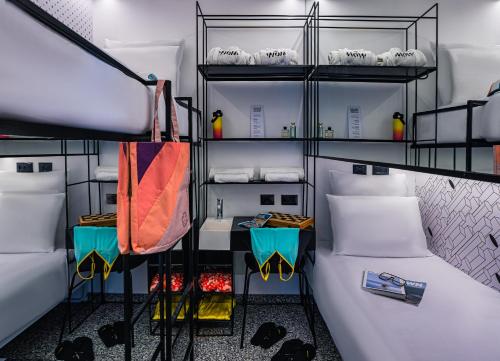 um quarto com um beliche com lençóis brancos em WOM Beach Pod Hotel - a member of Brown Hotels em Tel Aviv