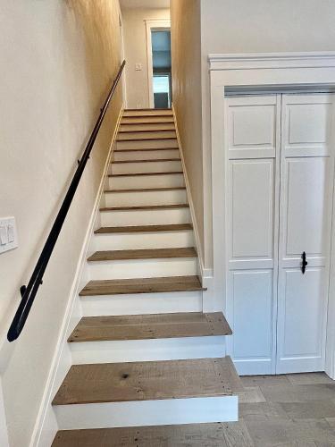 a staircase in a home with white walls and wooden floors at The Reminisce vacation home 5br/3bt,downtown BH in Bar Harbor