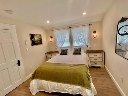 a bedroom with a large bed and two windows at The Reminisce vacation home 5br/3bt,downtown BH in Bar Harbor