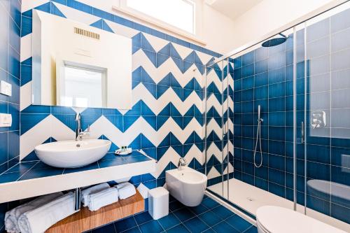 a blue tiled bathroom with a sink and a toilet at La Vigna di Bacco in Furore