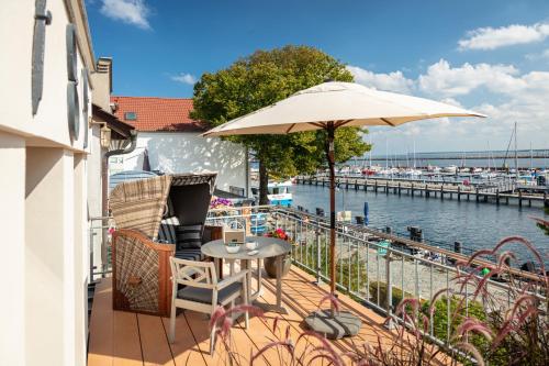 a balcony with a table and an umbrella at Kapitaenshaus in Wasserlage! Traumapartments Warnemuende in Warnemünde