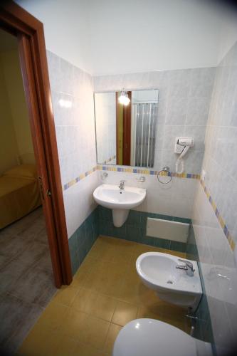 a bathroom with a sink and a toilet and a mirror at Abacus in Reggio Calabria