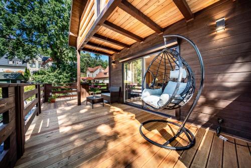 a porch of a house with a swing at Domki Miśków in Międzyzdroje