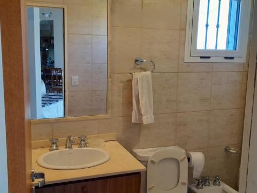 W łazience znajduje się umywalka, toaleta i lustro. w obiekcie LA PEDRERA - ESPECTACULARES VISTAS - Carlos Paz - Córdoba - Argentina w mieście Villa Carlos Paz