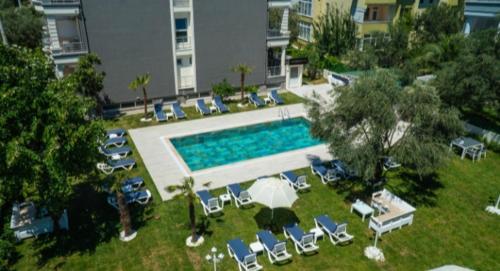una vista aérea de una piscina con tumbonas y una piscina en Platanus Hotel Altınoluk, en Altinoluk