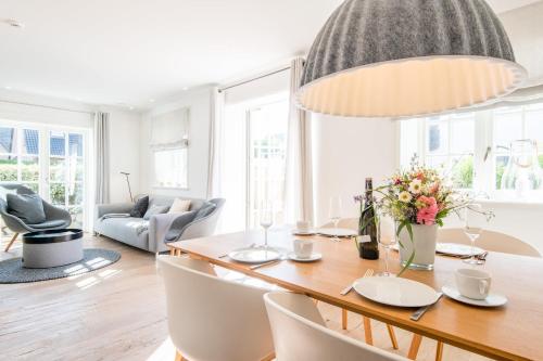 uma sala de jantar com mesa e cadeiras e um quarto em Landhaus Hygge em Wenningstedt