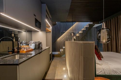 Apartaestudios Evolution Luxury في أليكانتي: مطبخ مع مغسلة وسرير في غرفة