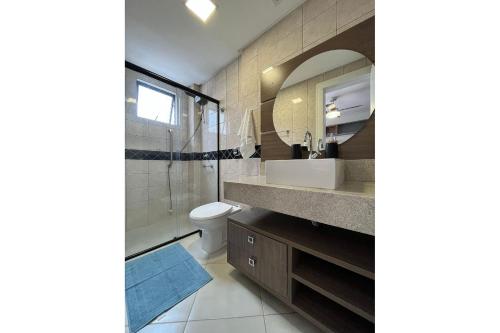 y baño con lavabo, aseo y espejo. en LN01- 3 Quartos| Churrasq | Tela | Berço | Garagem, en Balneário Camboriú