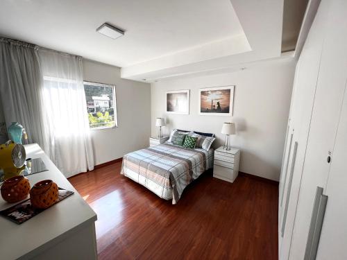 a bedroom with a bed and a wooden floor at AP VIAJANTE in Domingos Martins