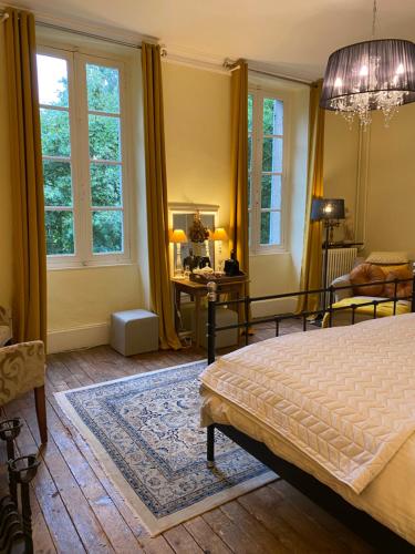 Schlafzimmer mit einem Bett, einem Schreibtisch und Fenstern in der Unterkunft Chateau du Grand Lucay in Bourbon-lʼArchambault