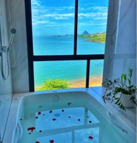 a bath tub with a view of the ocean at Hotel Espadarte in Iriri