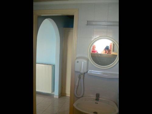 a bathroom with a round mirror and a sink at Room in BB - The Quality And Hospitalityof Apraos Bay Hotel Has Been Identified in Apraos