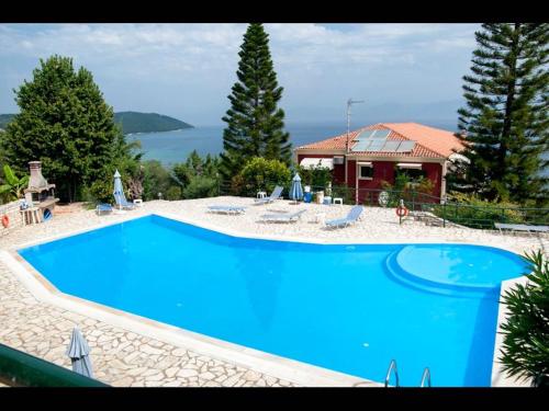una grande piscina blu di fronte a una casa di Room in BB - The Quality And Hospitalityof Apraos Bay Hotel Has Been Identified ad Apraos