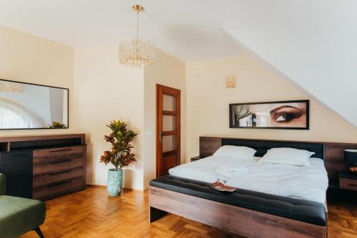 a bedroom with a large bed and a chair at Zarabie Residence in Myślenice