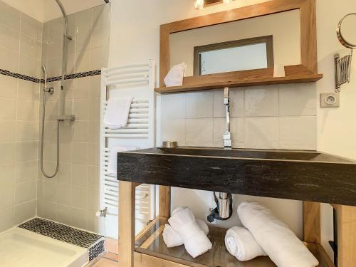 a bathroom with a sink and a shower at La Fontaine aux Poissons Rouges in Moussac