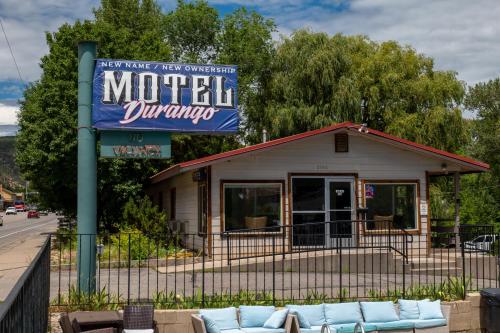 un cartel de motel con sofás frente a un edificio en The Junction Hotel and Hostel, en Durango