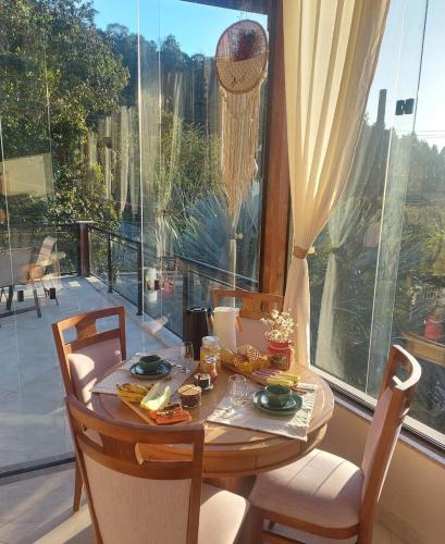a table with food on it in front of a window at Pousada dos Sonhos - MP in Miguel Pereira