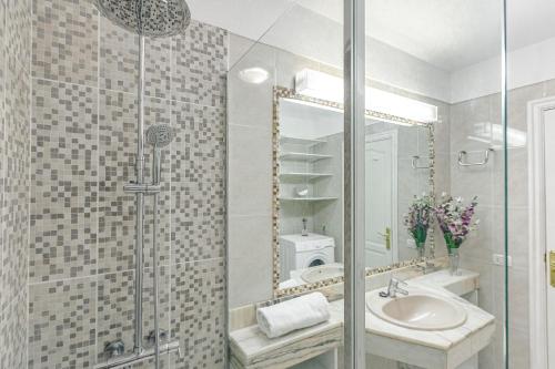 W łazience znajduje się prysznic, umywalka i lustro. w obiekcie AirCon Lovely 2 bedroom apartment close to Ocean w mieście Puerto de Santiago