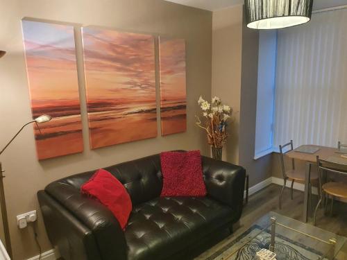 a living room with a leather couch and a table at The Savile - Luxury Apartment Leeds - Your Next Stay in Leeds