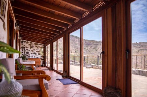 an open glass door on a patio with mountains in the background at Casa Rural La Palizada in Benchijigua