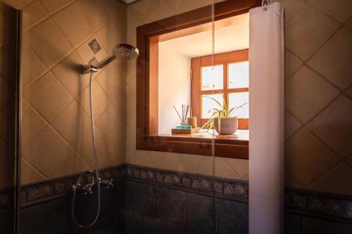 a shower in a bathroom with a window and a shower curtain at Casa Rural La Palizada in Benchijigua
